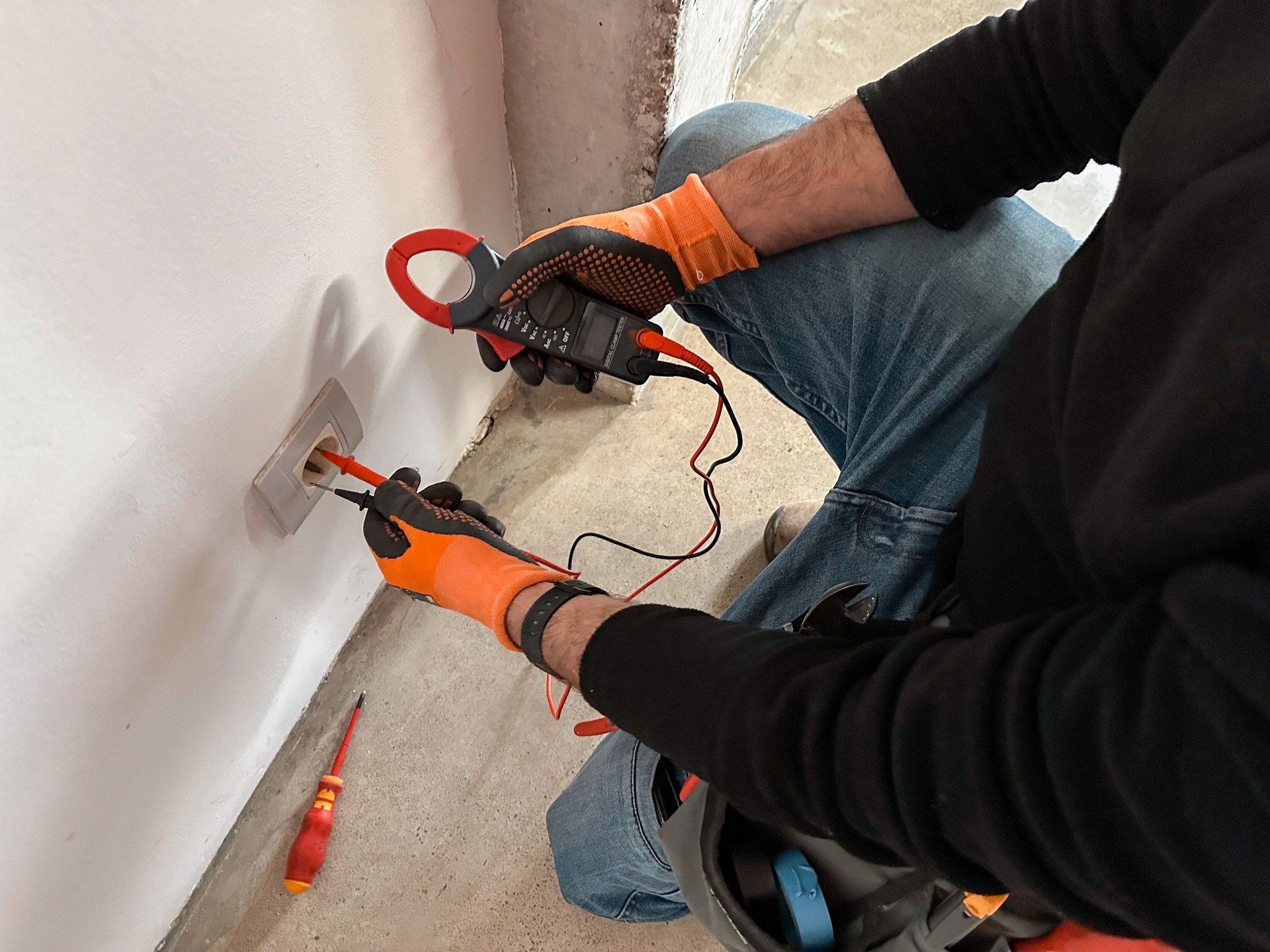 Electrician hands holding a multimeter clamp tester